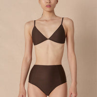 Woman wearing a brown minimalist triangle bikini top with adjustable straps and removable cups, paired with matching bottoms made with sustainable swimwear fabrics.