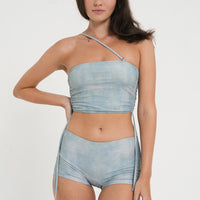 woman wearing a matching set of sea glass blue sustainable swimwear, consisting of a tankini top and low rise mini boy leg swim shorts.
